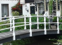 Kleine witte voetbrug in een tuin